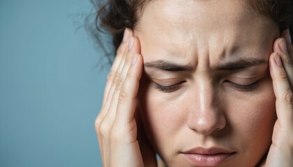 Fototapeta premium Close-up of young woman massaging temple experiencing headache. Mental health awareness concept relief from migraine pain through pressure point massage, seeking wellness, headache treatment, stress