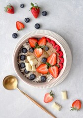 Vegan, healthy, and colourful porridge bowl with fresh fruits , white chocolate on a white background
