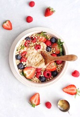 Vegan, healthy, and colourful porridge bowl with fresh fruits on a white background