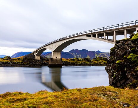 Concrete arch bridge over a calm river in a scenic landscape