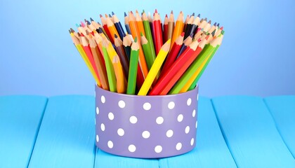 Colorful Pencils in Polka Dot Holder on Blue Wood