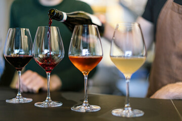 Sommelier pouring red wine into glass during wine tasting event