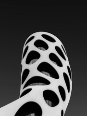 Modern building with white facade and organic-shaped cutouts against a dark background