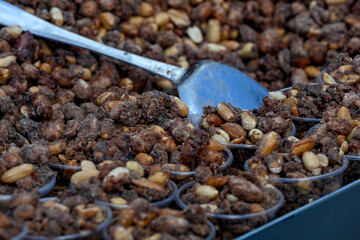 Candied mixed nuts in cups at a food market