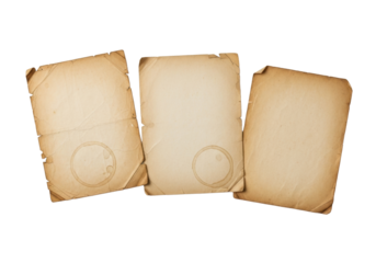 Three vintage paper sheets, artfully arranged on a transparent background in a flat lay, show varied textures, organic stains, torn edges, and yellowing, concept of preserved history and nostalgia