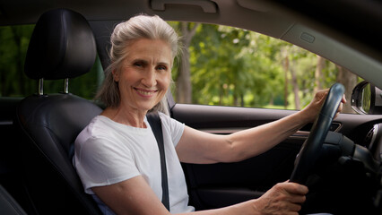 Happy smiling Caucasian mature senior elderly woman female auto owner lady grandmother automobile...