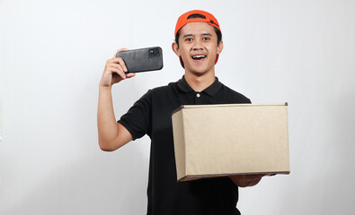 Excited delivery man holding box and phone ready to deliver your order today in a timely fashion