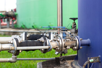 Industrial Water System Components Metallic Piping and Valves Connect Two Large Tanks Showing Water Treatment Infrastructure and Environmental Considerations for Public Health and Water Safety