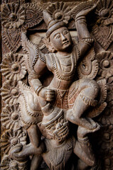 A detailed close-up of an intricate wooden carving depicting a mythological figure, showcasing the craftsmanship of Bagan's artisans.