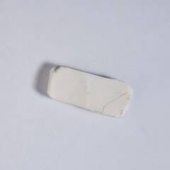 Used old uneven rubber pencil eraser object isolated on square white background from top angle view.
