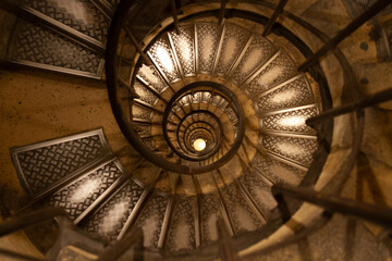 Looking Down a Vintage Spiral Staircase with Diamond Plate Steps and Warm Lighting