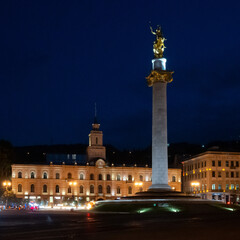 Obraz premium Iconic golden statue atop a column at Freedom Square in Tbilisi, Georgia. Monument celebrates Saint George slaying a dragon symbolizing the nation's independence after the Soviet Union.