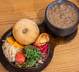 Authentic Georgian meal featuring hearty lobio (bean stew) and pickled jonjoli sprouts served with pickled vegetables and Mchadi (corn bread)