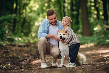 Father with son and dog are in the forest