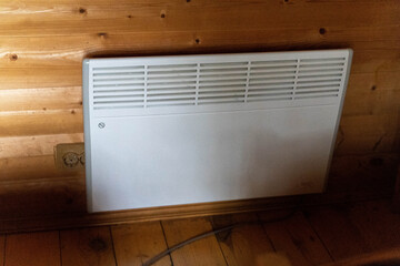 Electric convection heater providing warmth in wooden cabin