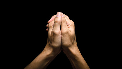 Hands clasped together in prayer, symbol of faith, hope, and peace against a deep black backdrop