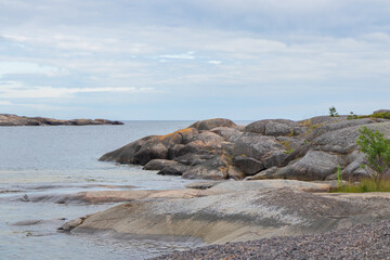 A peaceful coastal scene from a Finnish archipelago with pine trees, sea, and granite rocks. Protecting fragile island ecosystems and preserving the natural heritage. Jussaro, 2025