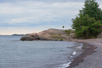A peaceful coastal scene from a Finnish archipelago with pine trees, sea, and granite rocks. Protecting fragile island ecosystems and preserving the natural heritage. Jussaro, 2025