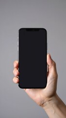 Hand holding a modern smartphone with a blank screen for mockup purposes