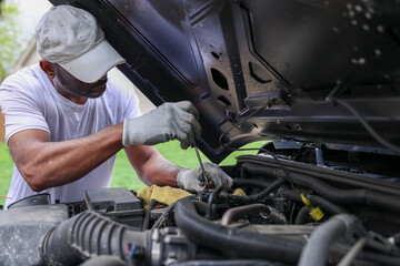 Fototapeta premium A portrait of a black man installing a car battery