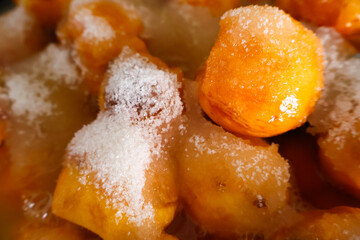 Fresh peach slices sprinkled with sugar, prepared for homemade jam making in a close-up view.