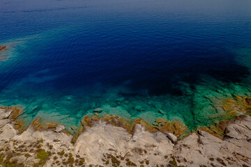 Aerial shot of a coastal landscape with clear blue waters.