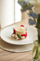 Elegant mousse dessert with flower petals on white plate