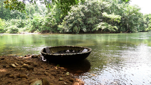A coracle boat moored on the banks of Kallar river at Adavi, Pathanamthitta, Kerala, India | Adavi Eco Tourism