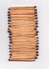 An ordered arrangement of wooden matches laid out in a long, neat row.