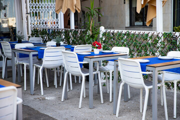 Mediterranean cafe atmosphere. Outdoor tables waiting for visitors