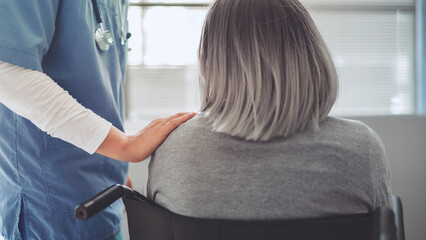 Healthcare worker with elderly patient in wheelchair