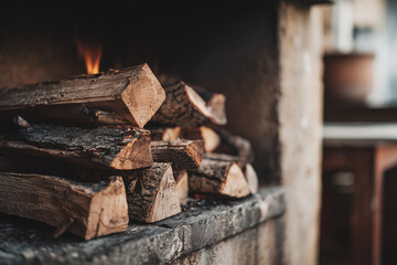 Fototapeta premium Firewood in smoker room for smoked food, Wooden log for charcoal making in kitchen, Firewood for cooking in backyard garden kitchen.