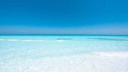 A serene view of a tropical beach with clear turquoise water and a bright blue sky on a sunny day
