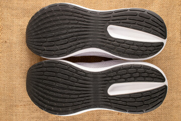 One pair of sneakers on jute canvas, close-up, top view.