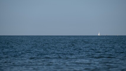 Obraz premium Minimal seascape with sailboat on the horizon