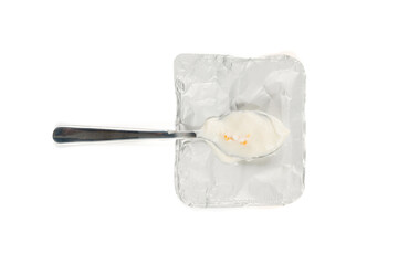 Yogurt cup isolated, yoghurt with orange fruits pieces in plastic pot, spoon in milk pudding