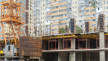 A frame made of load-bearing reinforced concrete walls during the construction of a multi-storey building. Reinforcement of reinforced concrete columns. Crane design with a lower counterweight.