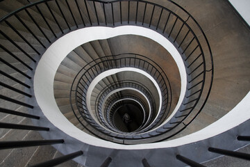 Descending Spiral Staircase with Architectural Symmetry and Black Railing