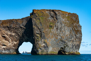 Fototapeta premium Dyrholaey is a 120 m high and precipitous headland. A large, natural gate has been eroded through its southernmost part. It is in south Iceland