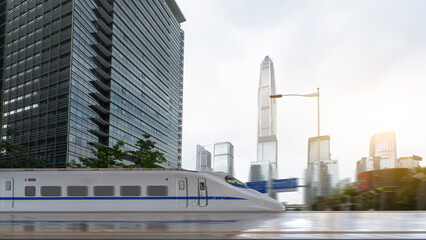 Naklejka premium High-speed train moving through modern cityscape with tall buildings