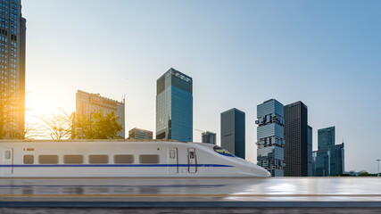 High-speed train moving through modern city with tall buildings