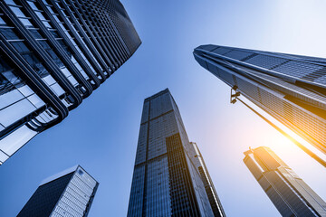 Looking up at modern skyscrapers against clear blue sky