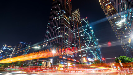 Night view of modern city skyscrapers with light trails