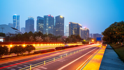 City night scene: modern skyscrapers and moving light trails