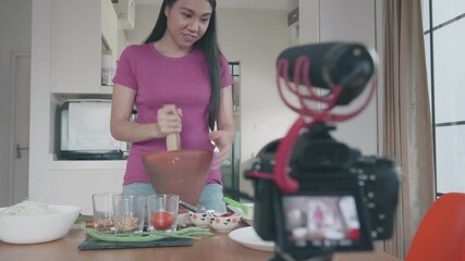 A woman demonstrates cooking techniques in a home kitchen, showcasing vibrant ingredients and engaging methods. Perfect for aspiring chefs looking to enhance their culinary skills.