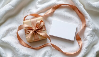 A flat lay with a silk ribbon looped beside a wrapped soap bar and a card that says for the one who always cared on a textured white fabric
