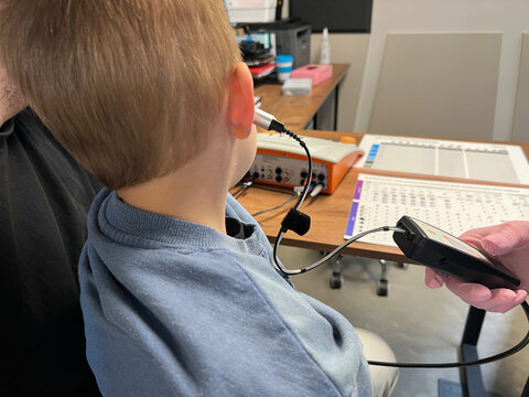 Child undergoing hearing test with audiometry device
