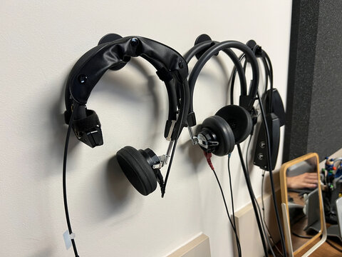 Professional audiometry headphones hanging on wall in clinic