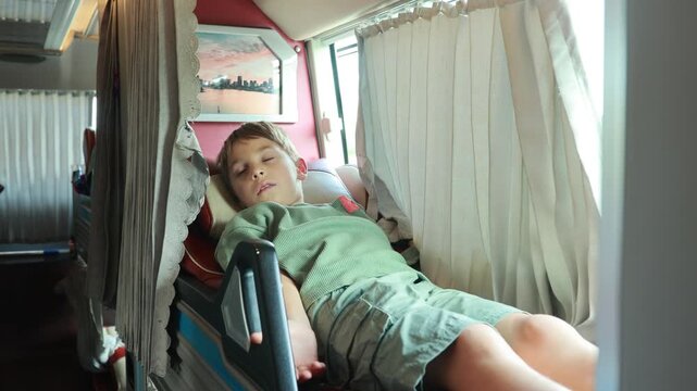 Child, boy, traveling in a sleeper bus in Vietnam, bed seat in the bus, kid on vacation in Viet Nam