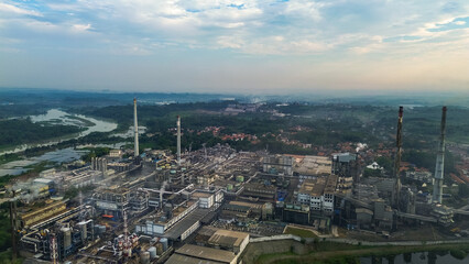 Aerial drone view of a large industrial factory complex with warehouses, chimneys, and storage tanks in Asia